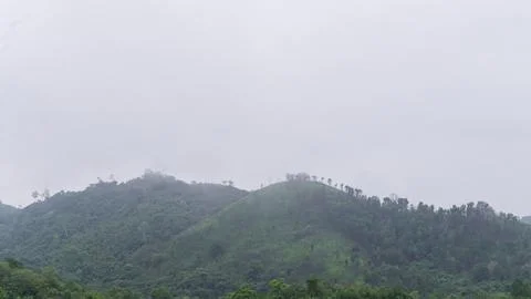 Mountains with greenery partially covered by clouds Stock Photos