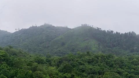 Mountains with greenery partially covered by clouds Stock Photos