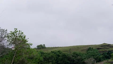 Mountains with greenery partially covered by clouds Stock Photos