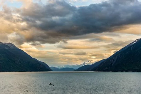Mountains &amp; Ocean with cloudy sky at sunset Glacier Bay Stock Photos