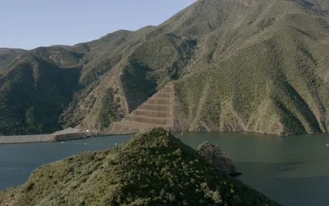 Mountains with pyramid along lake spring as sun sets on water 4K DRONE Stock Footage 129055912