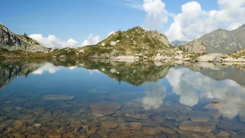 Mountains reflect on small alpine lake on the Bergamo Alps. Stock Footage 79655952