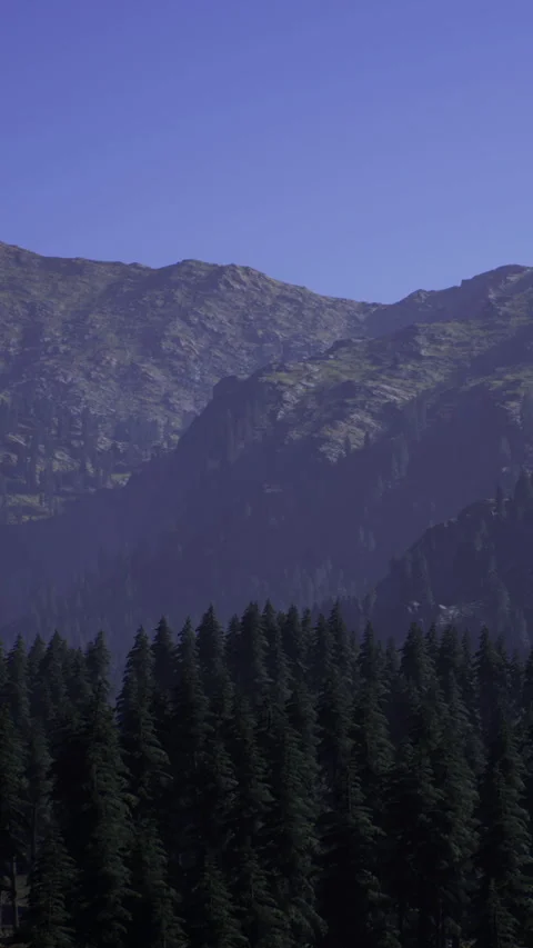 Mountains rise above trees in a distant landscape during daylight hours Stock Footage 331747312