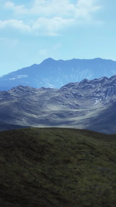 Mountains rise under blue sky with light clouds and green valley below Stock Footage 339780718