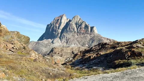 Mountains rise under clear blue sky in a remote location during daytime Stock Footage 339999072