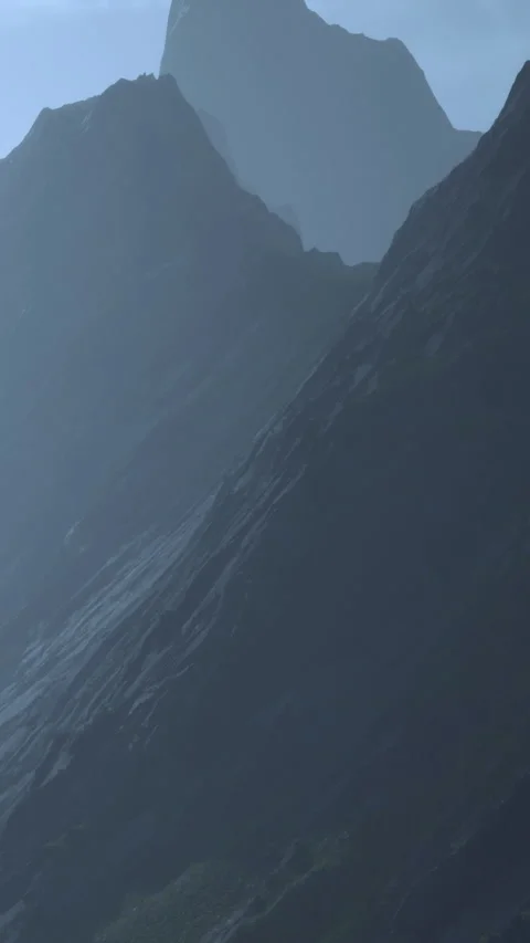Mountains rise under a cloudy sky near a distant peak in the background Stock Footage 341233627