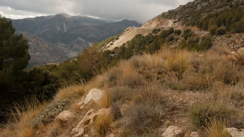 Mountains scenery, dramatic cloudy sky, no snow, small vegetation, one road Stock Footage 121259741