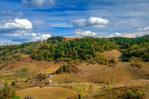 The mountains showing their fall colors under a blue sky with beautiful clouds. Stock Photos
