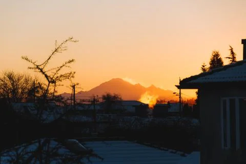 Mountains in snow with building in front while sunset or sunrise Stock Photos