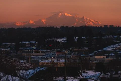 Mountains in snow with building in front while sunset or sunrise Stock Photos