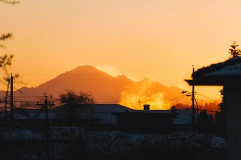 Mountains in snow with building in front while sunset or sunrise Stock Photos