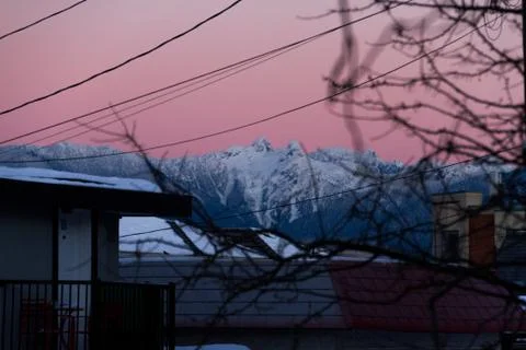 Mountains in snow with building in front while sunset or sunrise Stock Photos
