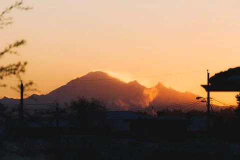 Mountains in snow with building in front while sunset or sunrise Stock Photos