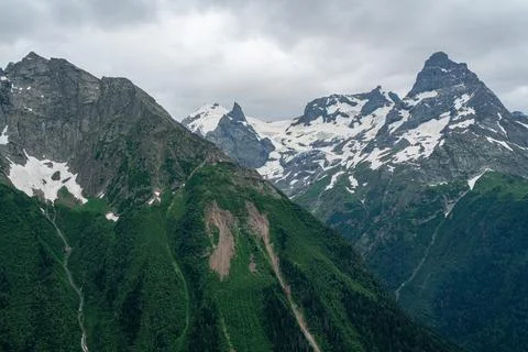 Mountains with snow in a cloudy sky Stock Photos