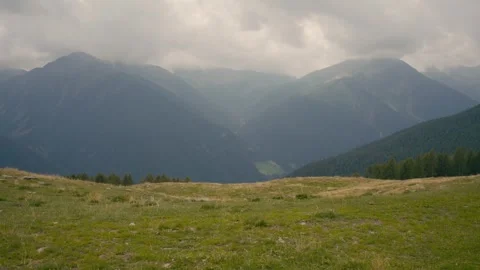 Mountains in South Tyrol with Dramatic Clouds over a Green Alpine Meadow 库存影片 331168176