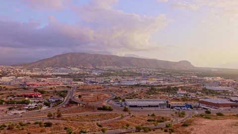 Mountains stand over a city as clouds move in the sky during sunset near th.. Stock Footage 340192706