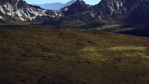 Mountains stand tall under the bright sun with clear skies in the background Stock Footage 345064142