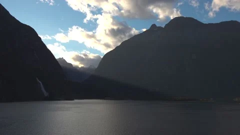 Mountains in the sun and sky with clouds in New Zealand Milford Sound Stock Footage 132063060