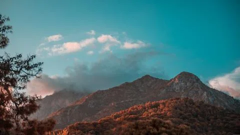 Mountains in the sunet, covered in clouds. Stock Photos