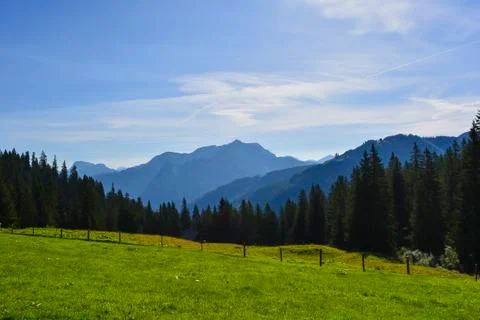 Mountains Sunshine Clouds Meadow with clouds and trees Stock Photos