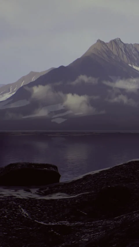 Mountains surround a calm lake with clouds in the early morning light Stock Footage 334191148