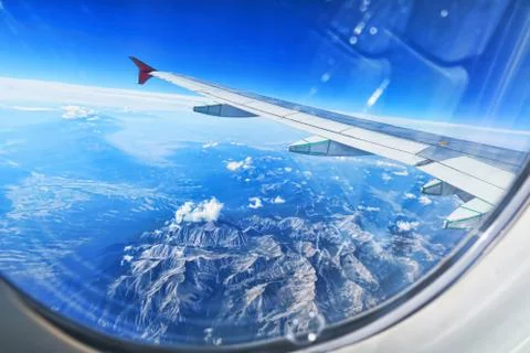 Mountains through an airplan window Stock Photos
