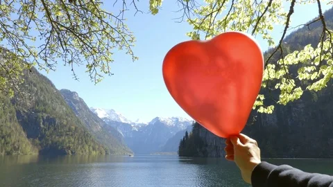 Mountains through red balloon in shape of heart Stock Footage 75167136
