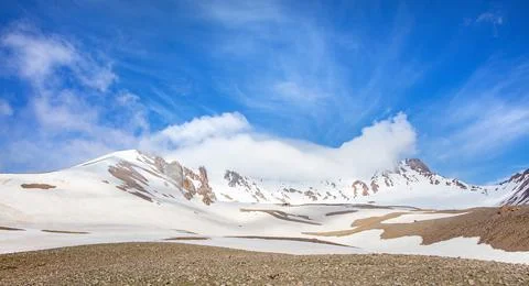 Mountains under blue sky with clouds and snow in the background during dayt.. Stock Photos