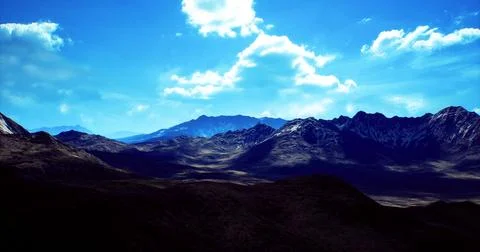 Mountains under bright blue sky with scattered clouds during daytime 스톡 일러스트