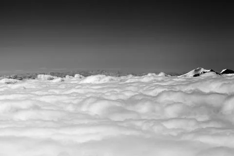 Mountains under clouds in sun winter day. Black and white. Stock Photos