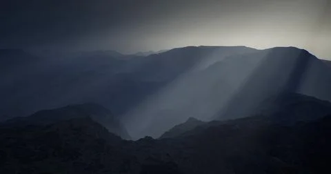 Mountains under dramatic cloud cover at dusk with striking sun rays Stock Illustration