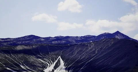Mountains with unique lines and textures under a clear blue sky Stock Illustration