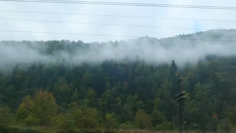Mountains view outside train window. Fog over mountain peaks in the morning Stock Footage 263488211