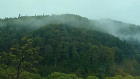 Mountains view outside train window. Mountain peaks in the morning fog Stock Footage 263488318