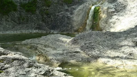 In the mountains, a waterfall is flushing into a natural pool Stock-Footage 211743885