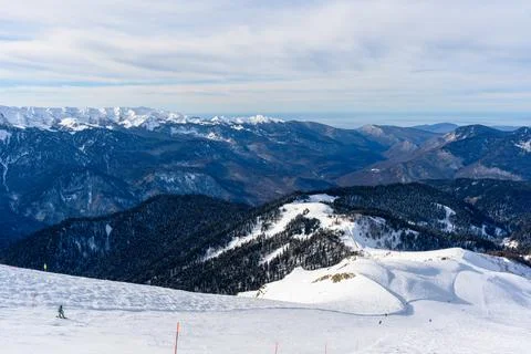 A mountainside with skiers going down. Stock Photos