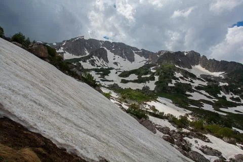 Mountainside Snowscape Under a Cloudy Sky Stock Photos