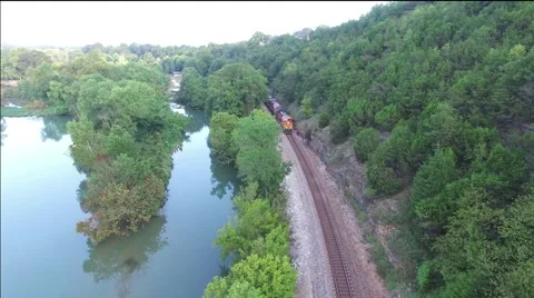 Mountainside train track beside river Stock Footage 68137456