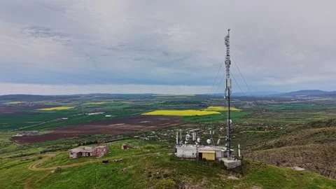 Mountaintop view of fields and a communication tower in springtime Video stock 338275884