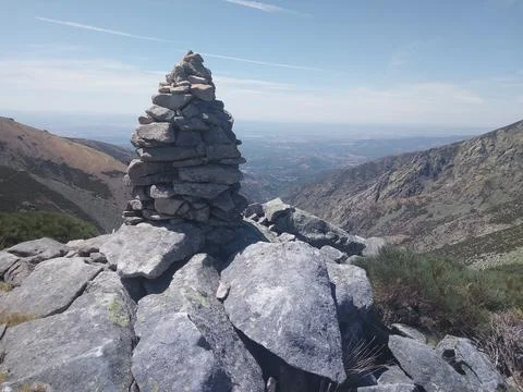 A mountaintop viewpoint marked by a large stone cairn Stock Photos