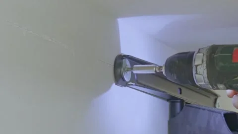 Mounting a fixture on a light wall using a cordless drill driver and bit ex.. Stock Footage 340549095