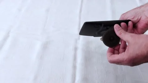 Mounting a GPS Device- Hands Demonstrating Setup on White Surface Stock Footage 311752362