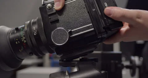 Mounting Mamiya RB67 medium format camera onto professional tripod in studio. 库存影片 313981018