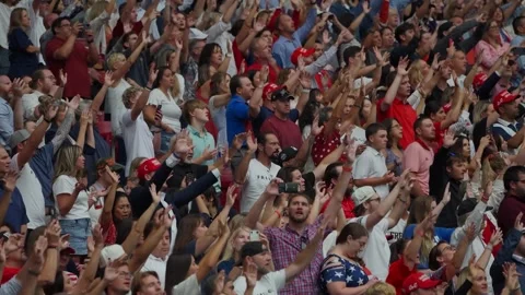Mourners raise their hands in the crowd at the Charlie Kirk memorial service Stock Footage 345298020