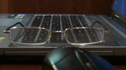 Mouse, glasses lie on a keyboard Stock Footage 33754981