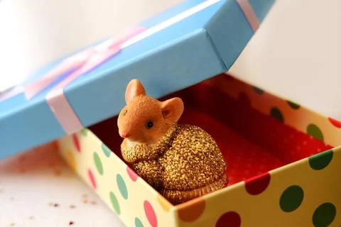 Mouse sits in a gift box.Box with a blue lid and a pink bow Stock Photos