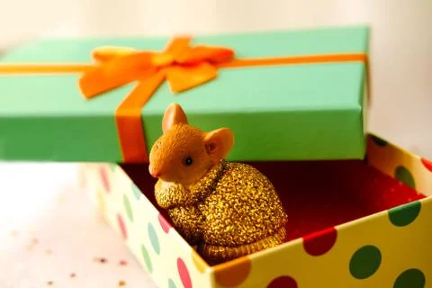 Mouse sits in a gift box.Box with a green lid and a orange bow Stock Photos
