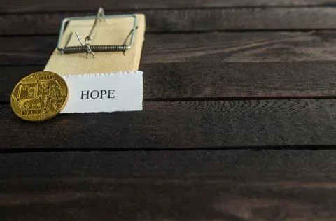 Mouse trap, backside of bitcoin and the word: Hope. Stock Photos