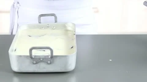 Moussaka in a baking dish being covered with aluminium foil Stock Footage 24671251