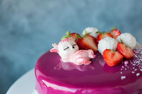 Mousse cake covered with pink icing, decorated with a figurine of a white cho Stock Photos